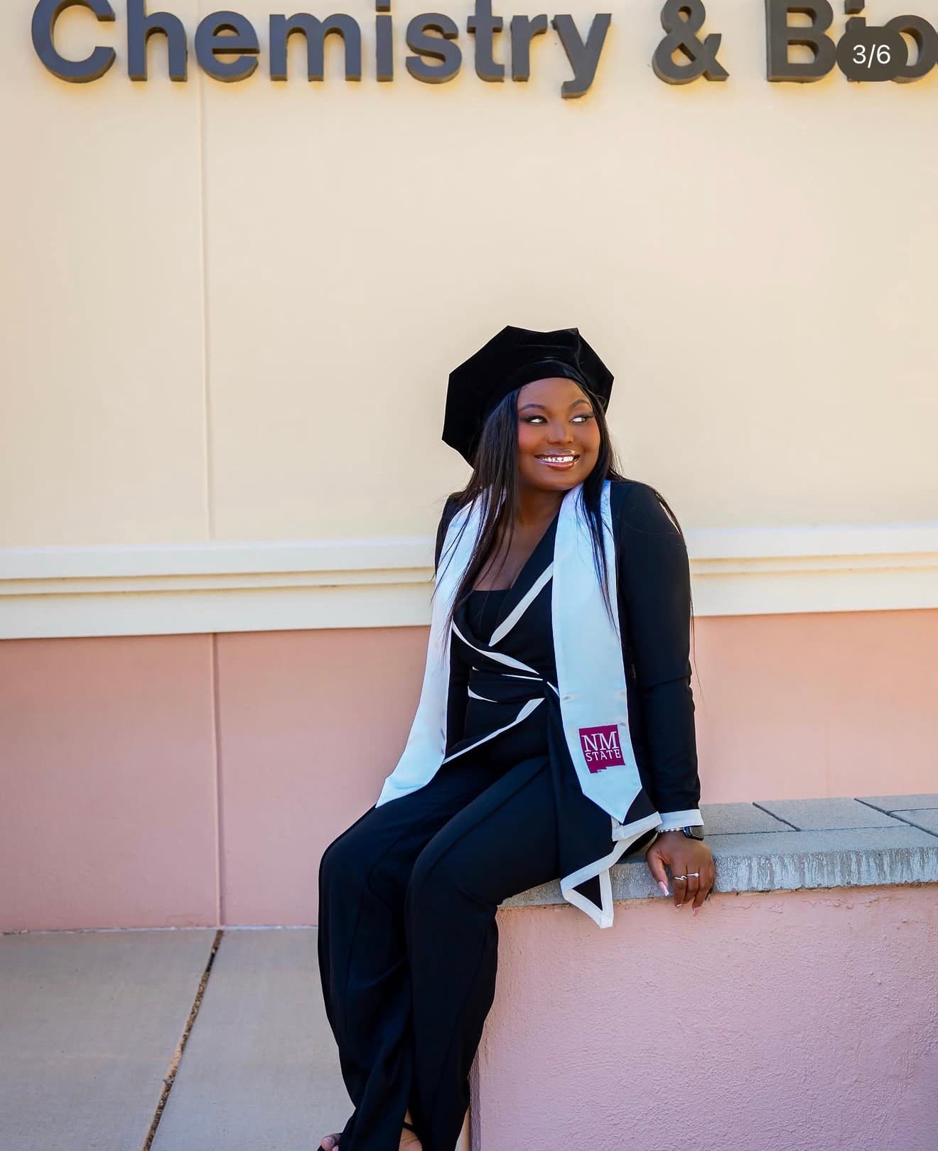 Graduate smiling outside the Chemistry & Biology building