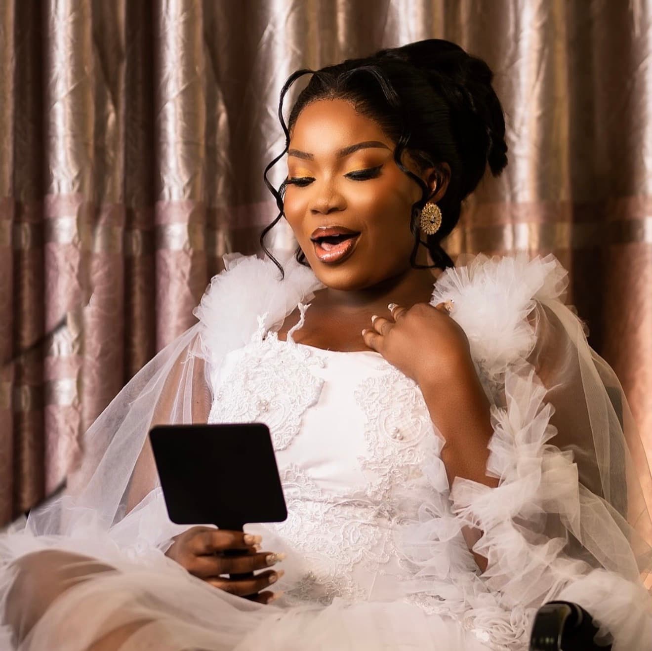 Bride laughing while checking her mirror