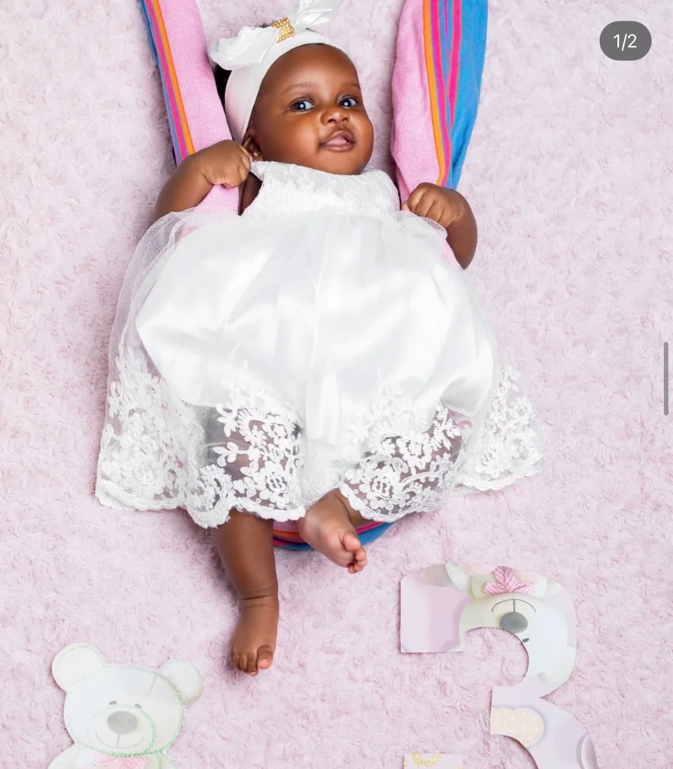 Baby in a white lace dress with a bow headband