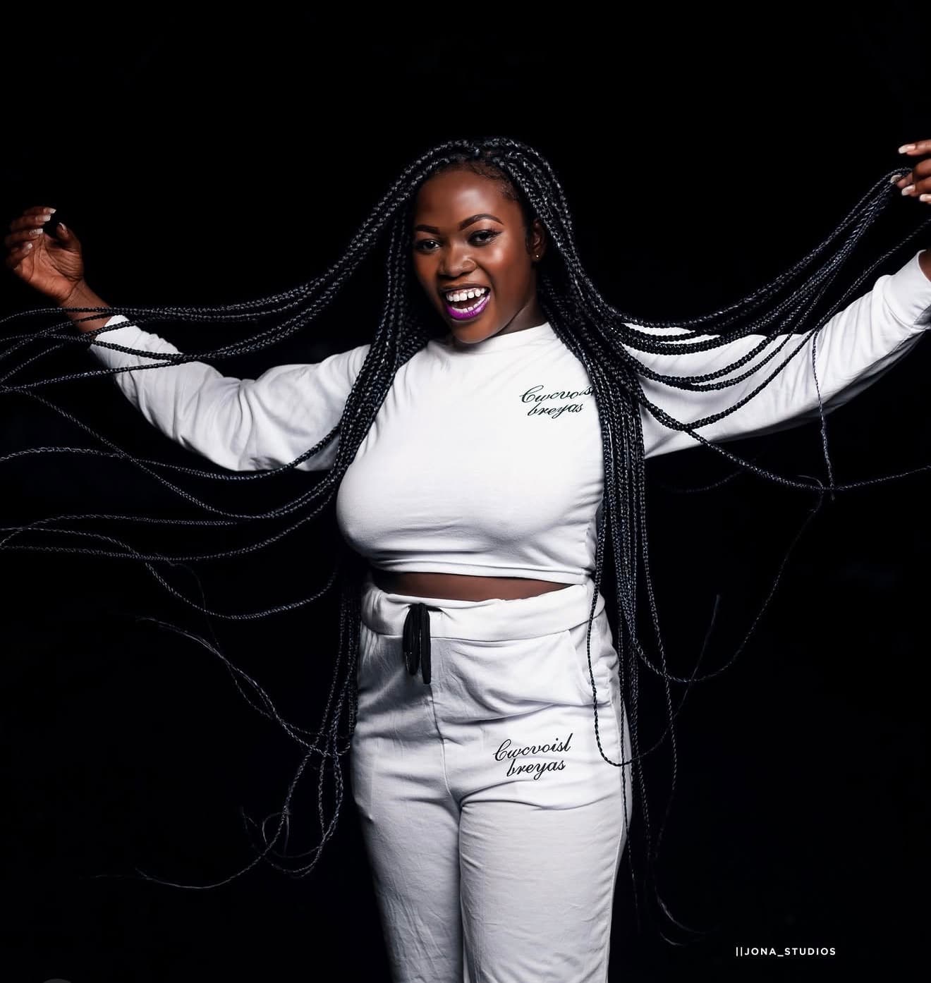 Model wearing branded apparel against a black backdrop