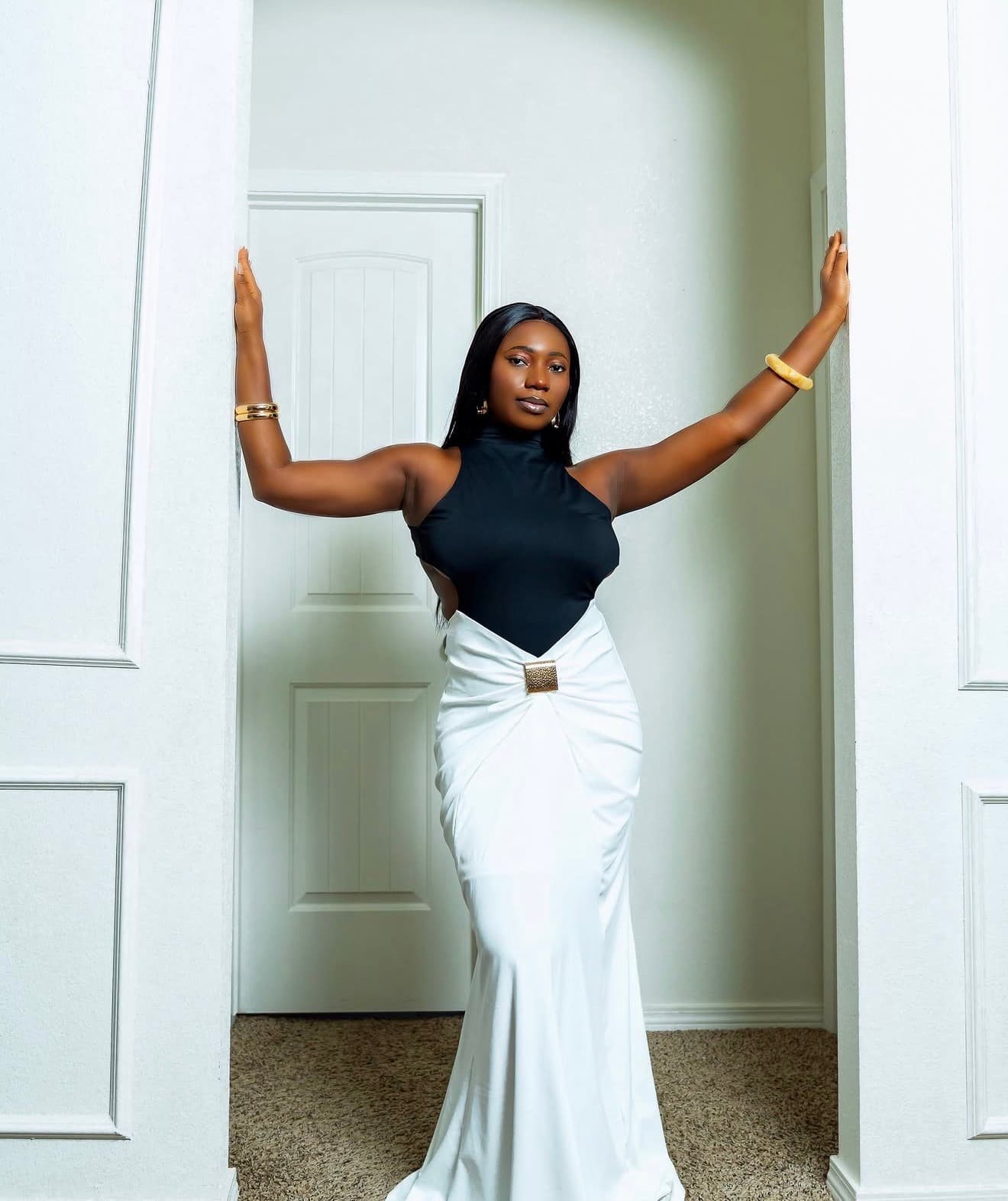 Model posing in a doorway in a black and white outfit